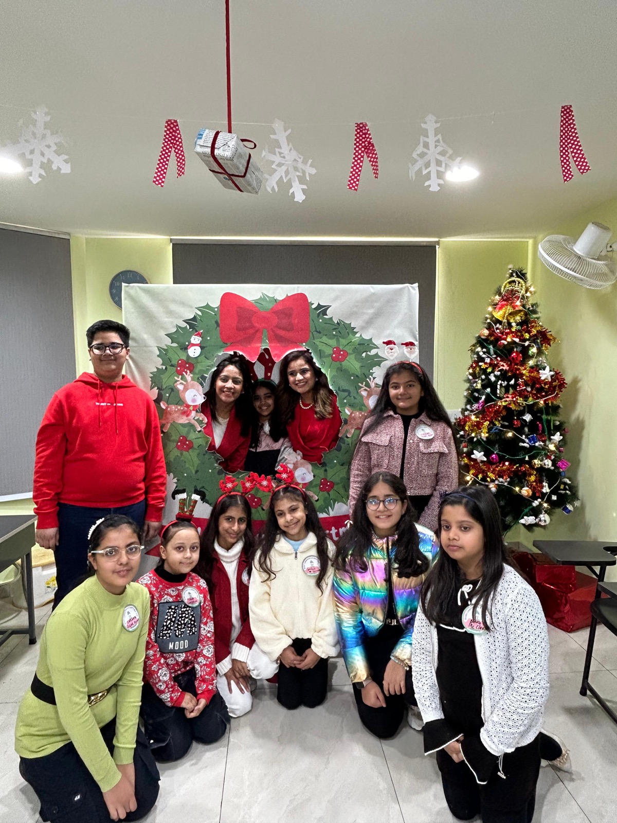 Students and team at a Christmas wreath photo booth