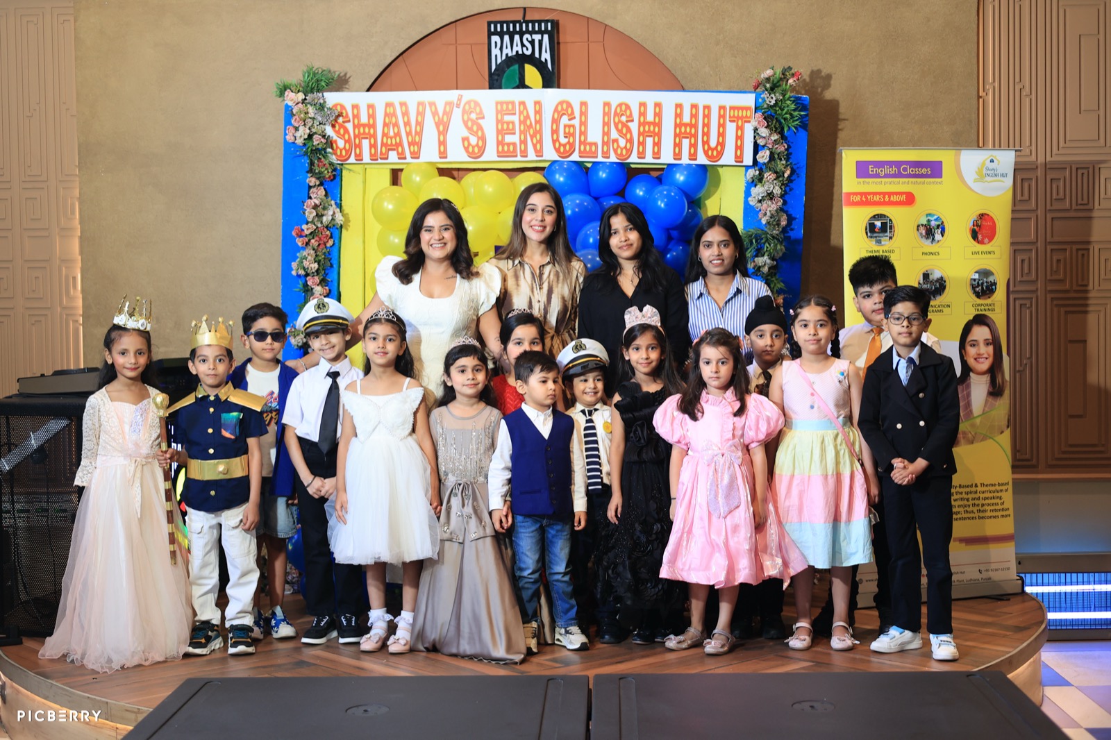 Students in costume with Shavy's English Hut founders on stage