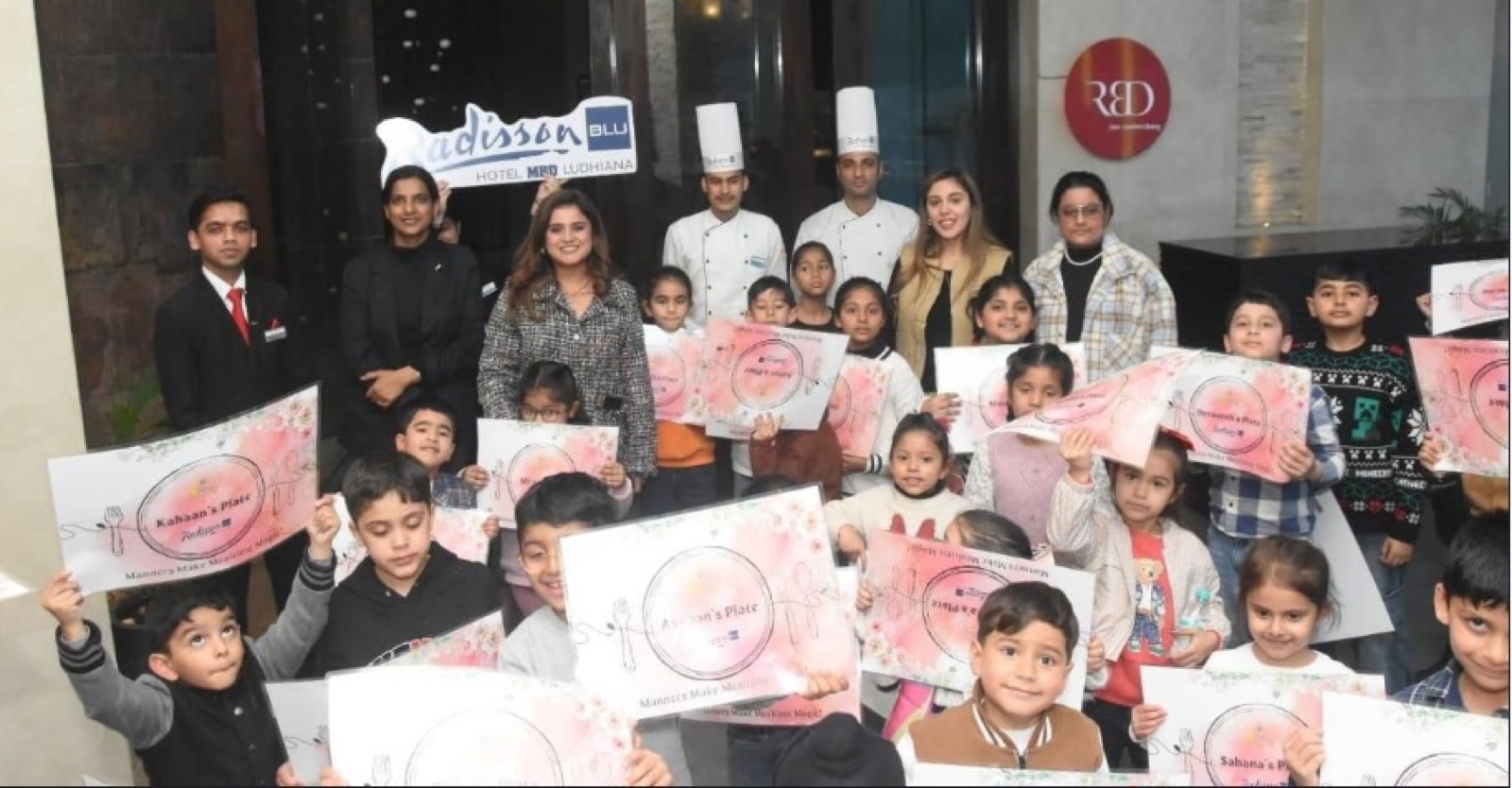 Students with team and chefs at a dining etiquette event at Radisson Blu Hotel