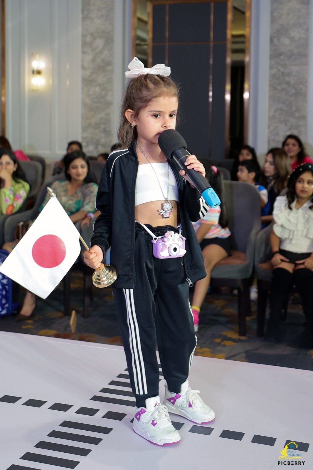 Student holding a flag and microphone on stage
