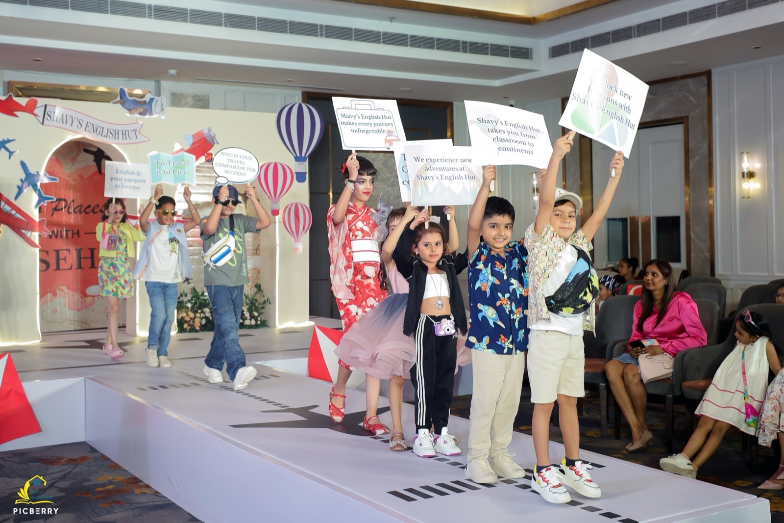 Students on stage with Shavy's English Hut placards