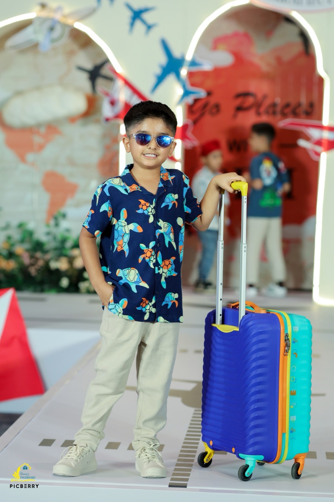 Student on stage with a suitcase prop